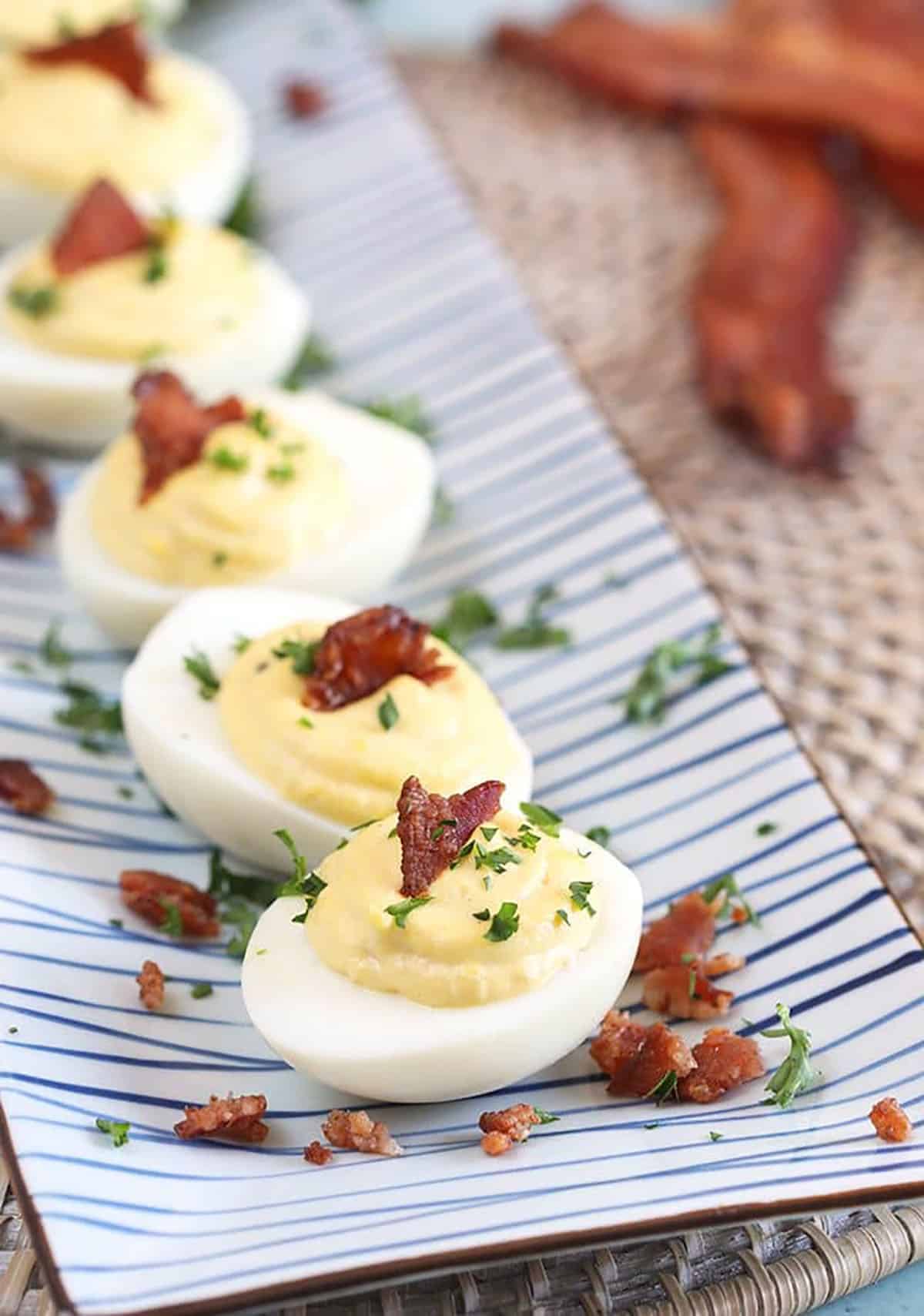Bacon Horseradish Deviled Eggs on a blue and white rectangle platter.
