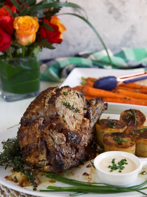 A prime rib roast is presented on a white plate.