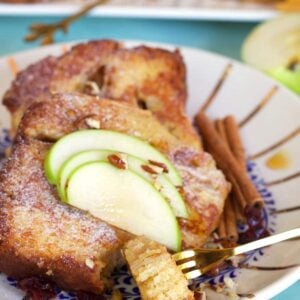 Sliced apple pieces garnish a serving of French toast.