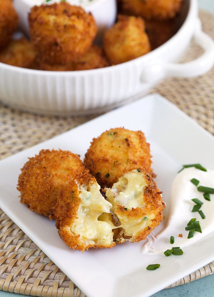 Several croquettes sit on a white plate.