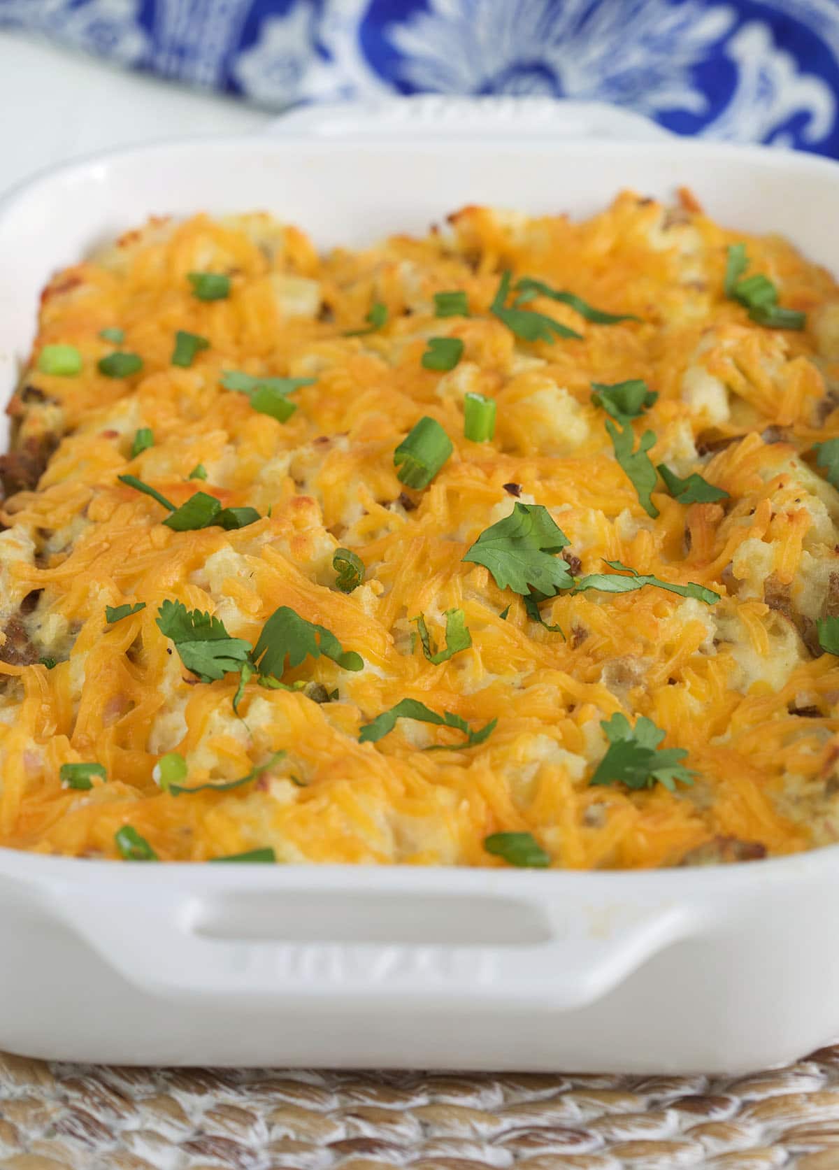 Baked potatoes and cheese are in a casserole dish.