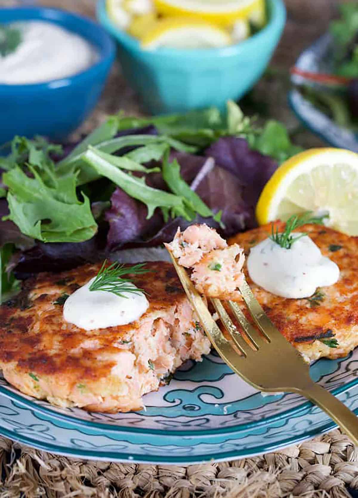 Salmon Cake recipe on a decorative plate with a fork and lemons