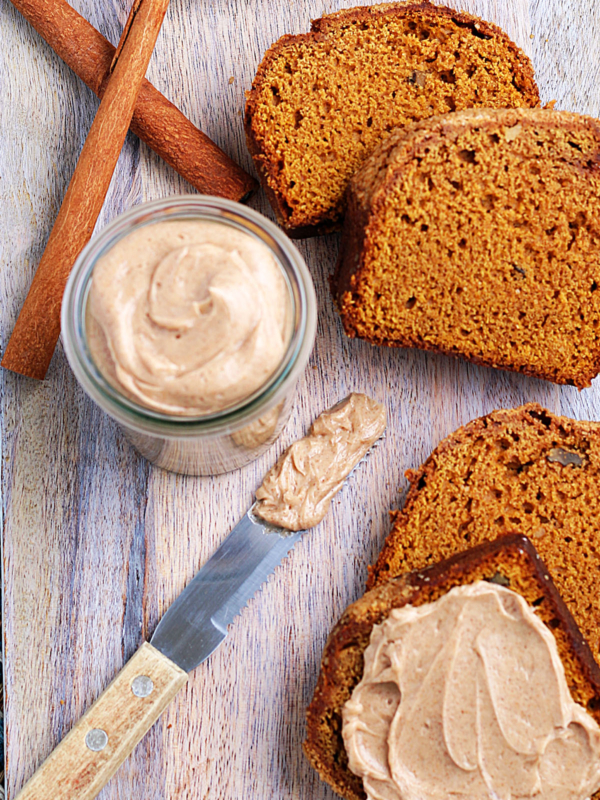 Cinnamon sticks are placed next to a sliced loaf of bread and a jar of Texas Roadhouse butter.