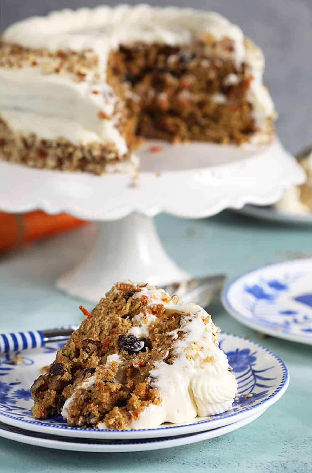 Carrot Cake Layer cake with a slice on a blue and white plate.