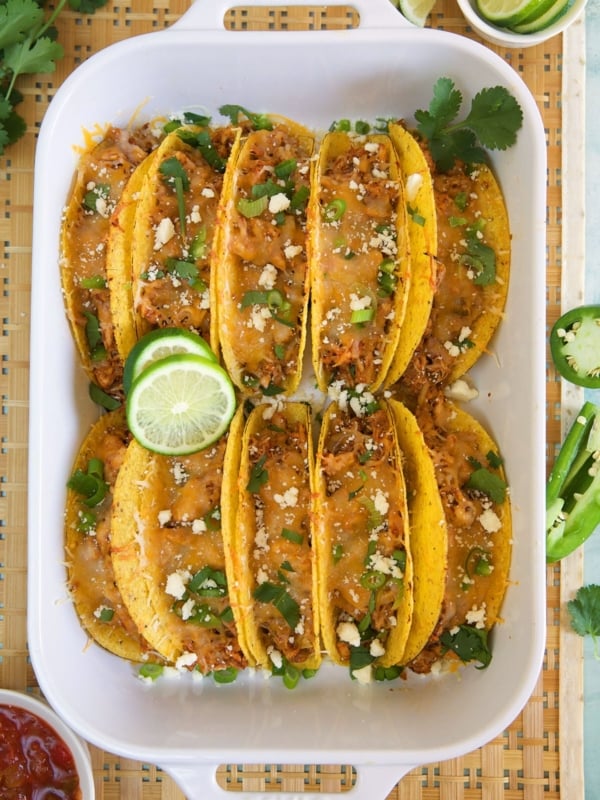 Ten tacos are placed in a large baking dish.