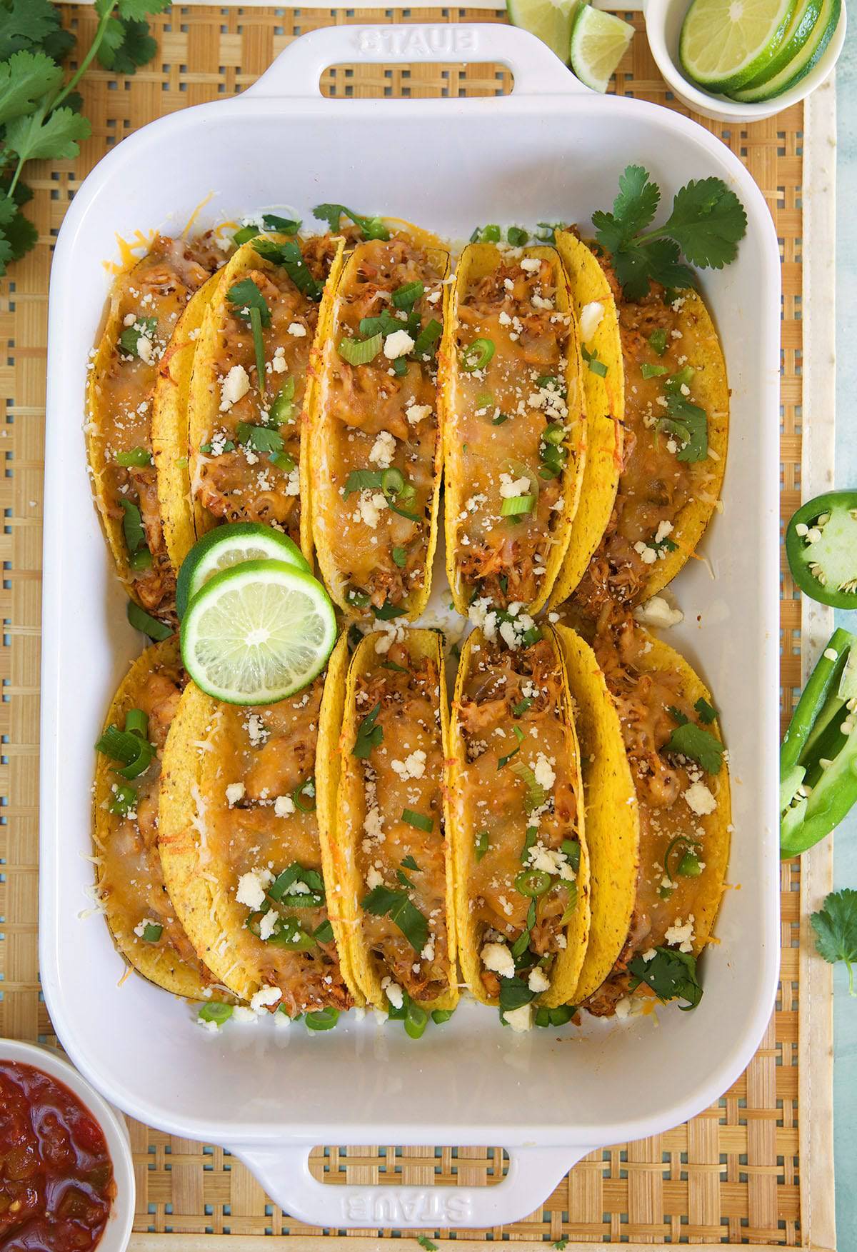 Ten tacos are placed in a large baking dish.