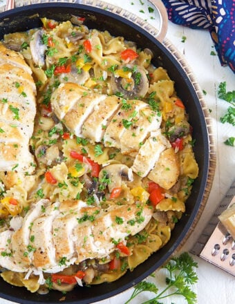 A large skillet is filled with pasta and chicken.