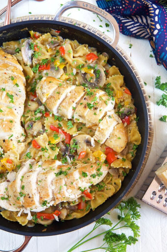 A large skillet is filled with pasta and chicken.