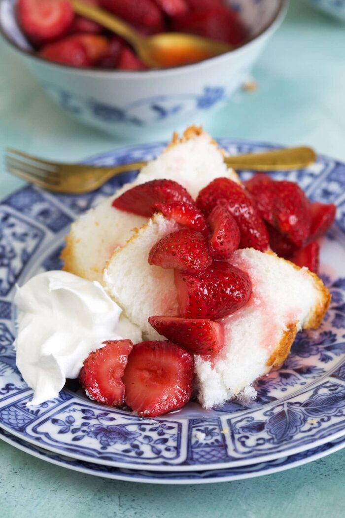 Pieces of cake are covered in macerated strawberries.