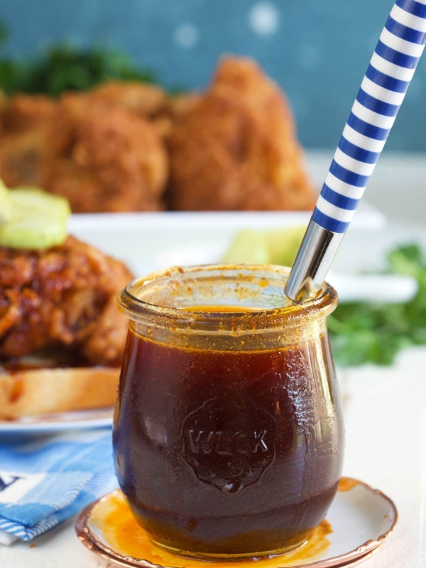 A spoon is placed in a jar of hot sauce.