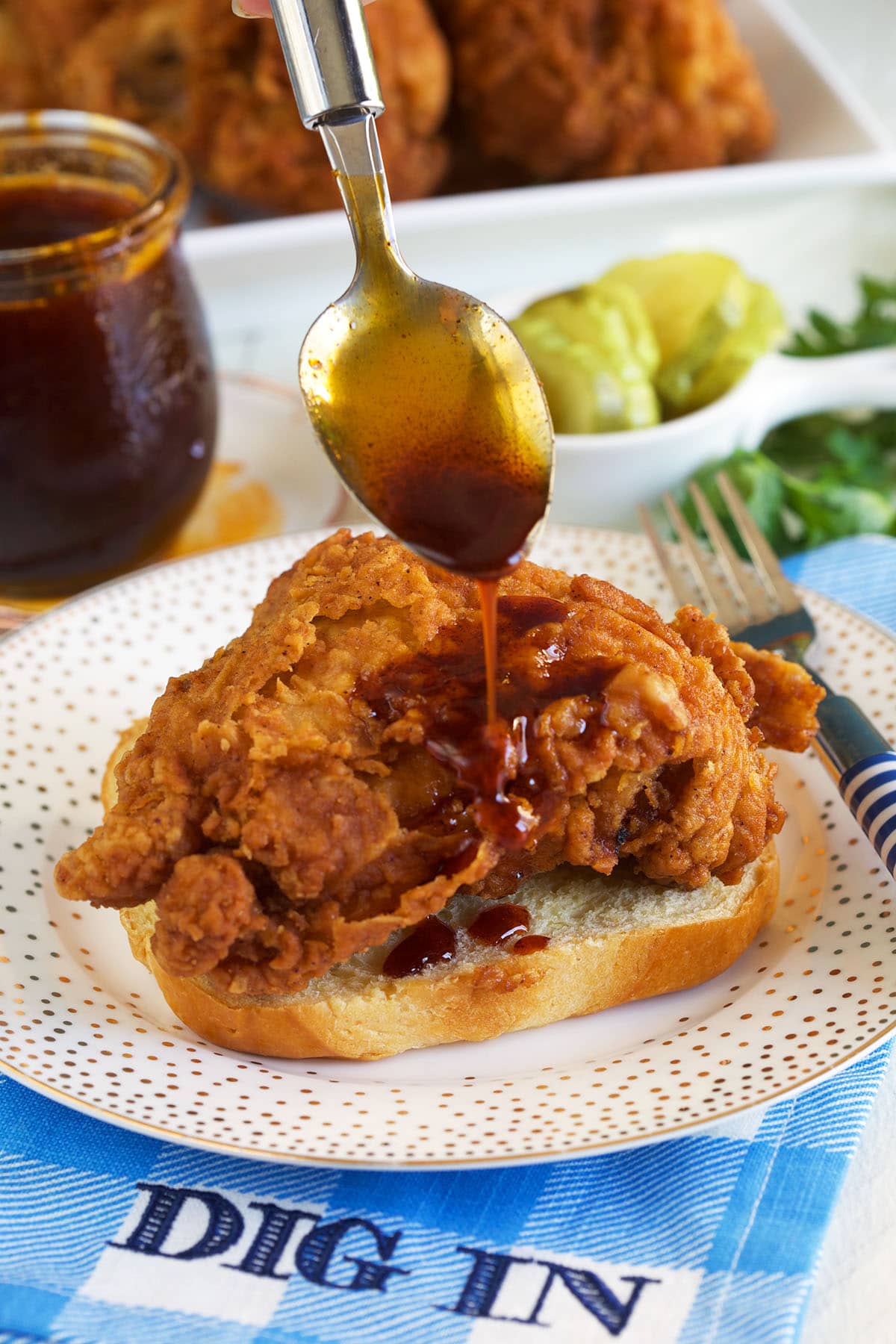 Nashville hot sauce is being drizzled over a piece of fried chicken. 