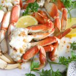 Crab legs are cooked and arranged on a white plate.