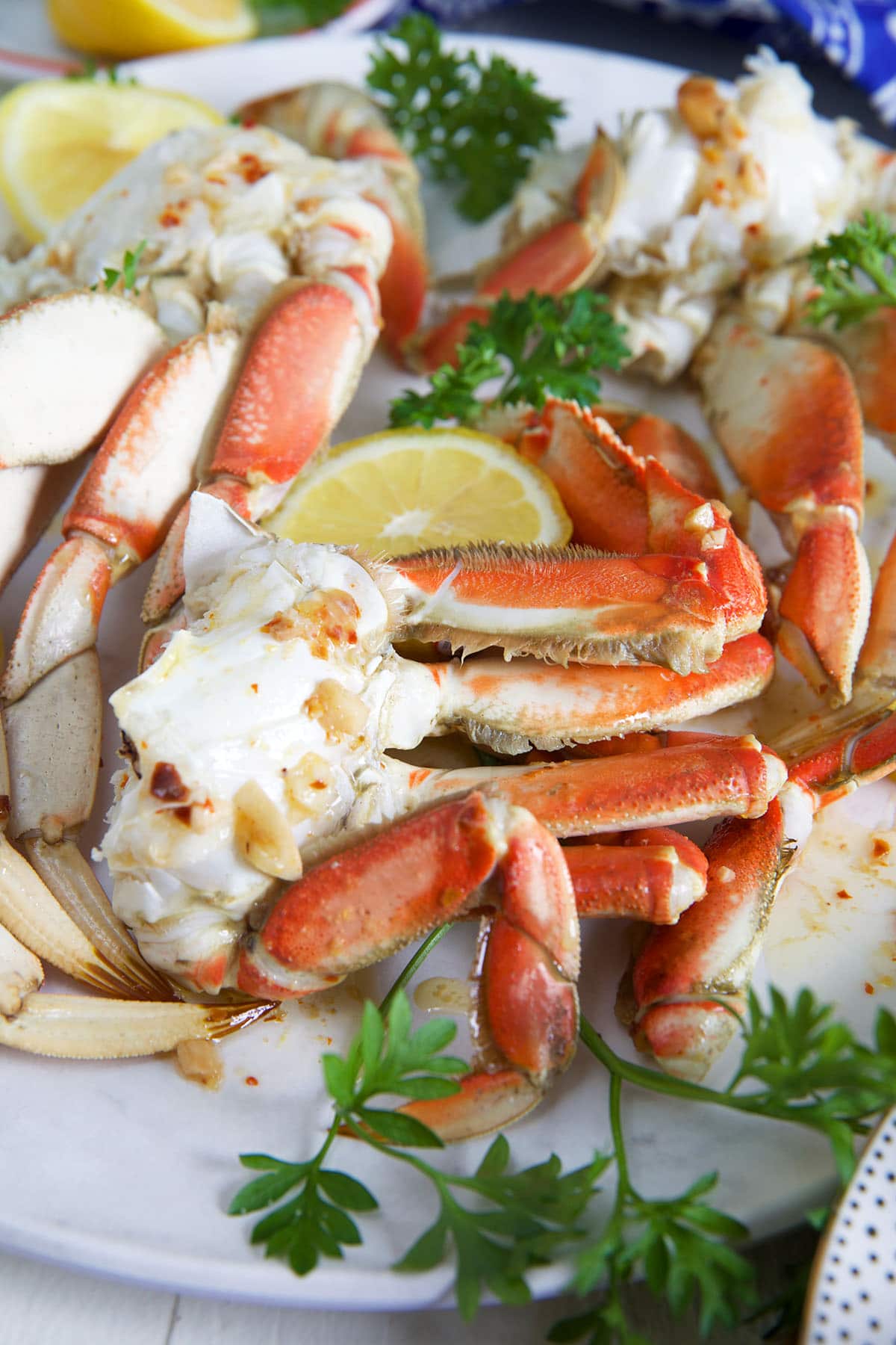 Crab legs are arranged on a plate next to a lemon slice.
