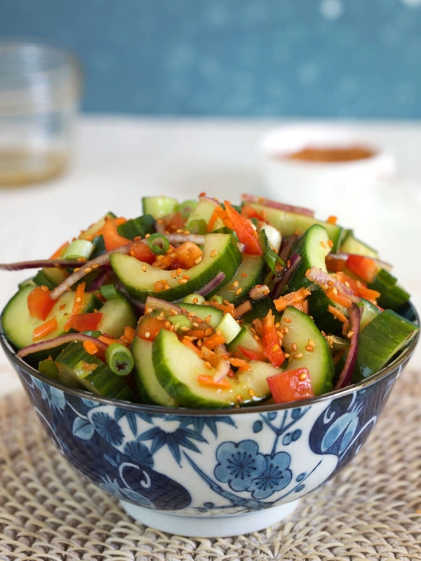 A large salad is placed in a bowl on a placemat.