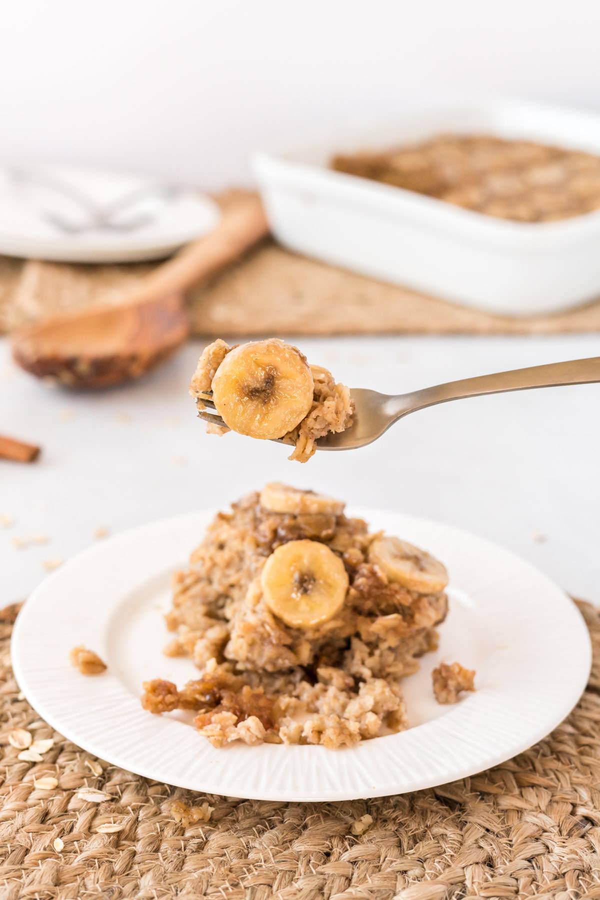 Bananas Foster Baked oatmeal on a white plate with a fork full of oatmeal