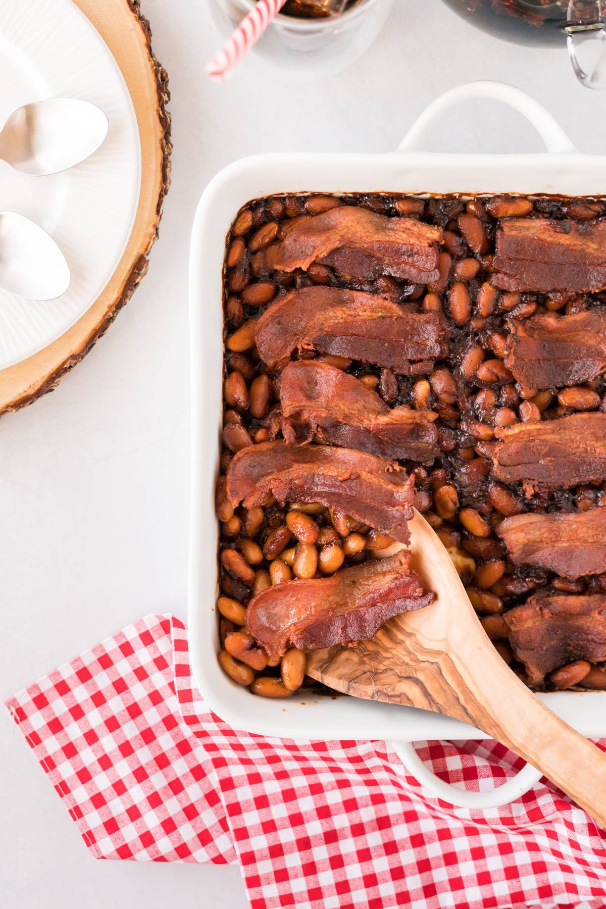 BBQ Baked Beans in a white casserole dish with bacon on top.