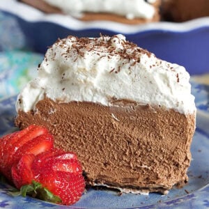 Chocolate Mousse Pie slice on a blue plate with a strawberry.