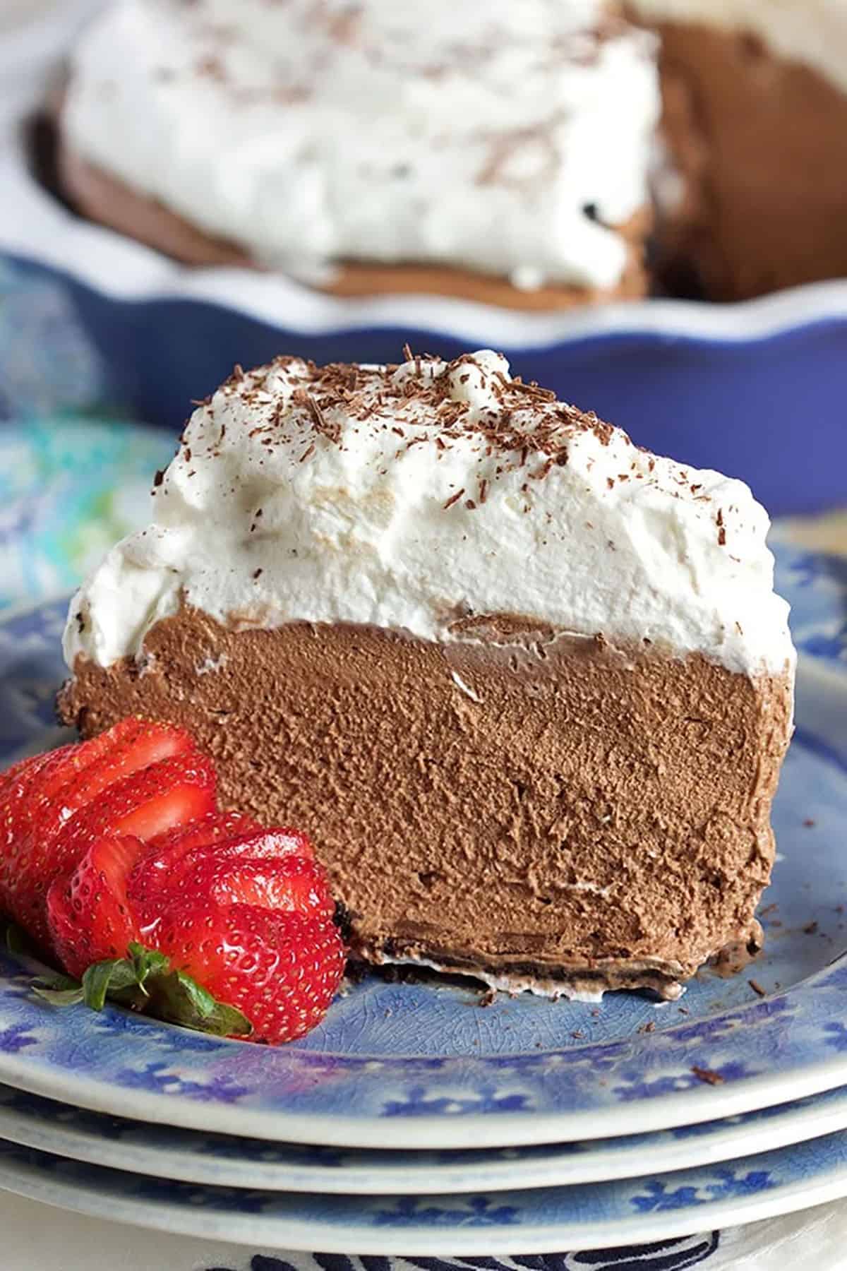 Chocolate Mousse Pie slice on a blue plate with a strawberry.