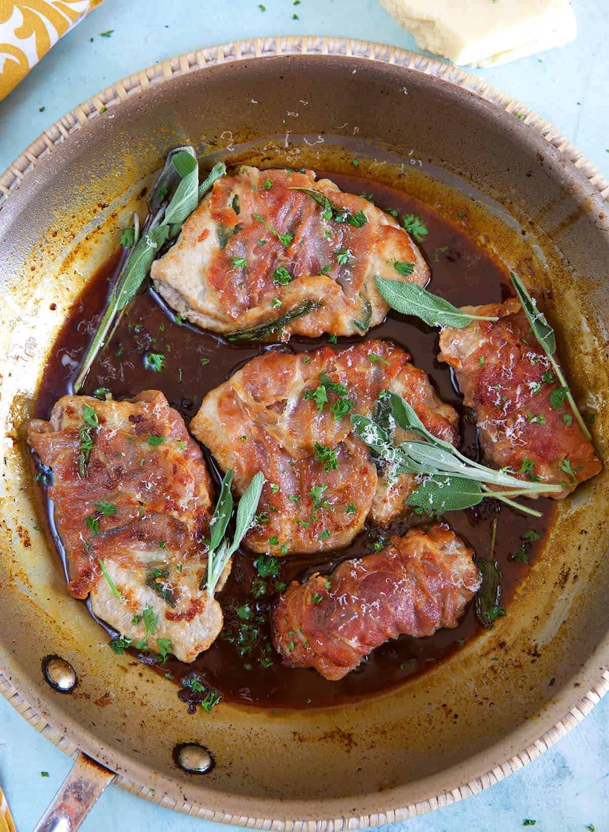 Veal Saltimbocca in a skillet with fresh sage.