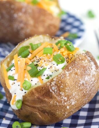 A baked potato is filled with sour Crean, chives, black pepper and cheese.