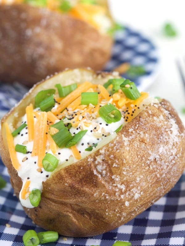 A baked potato is filled with sour Crean, chives, black pepper and cheese.