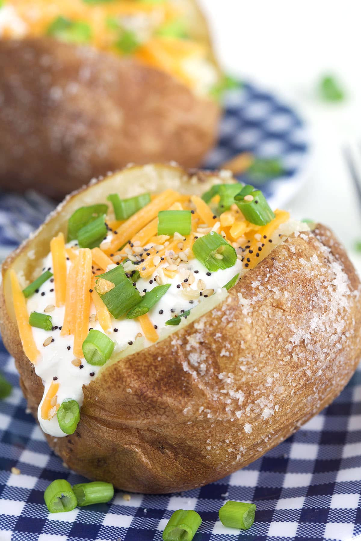 A baked potato is filled with sour Crean, chives, black pepper and cheese. 
