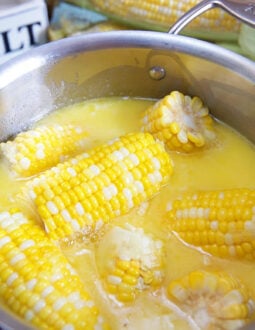 Corn on the cob in a stainless steel pot.
