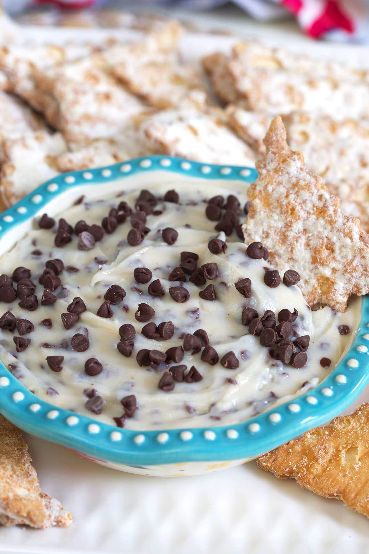 A small blue and white bowl is filled with sweet cannoli dip. 