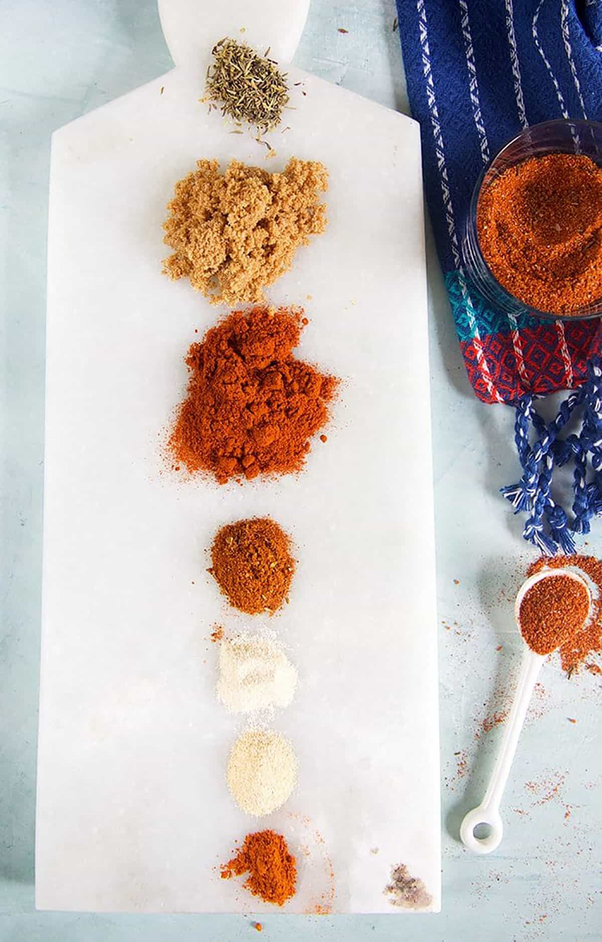 Piles of spices on a marble board.