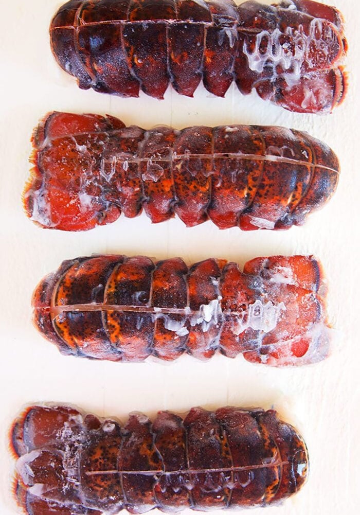 Frozen lobster tails on a white background.