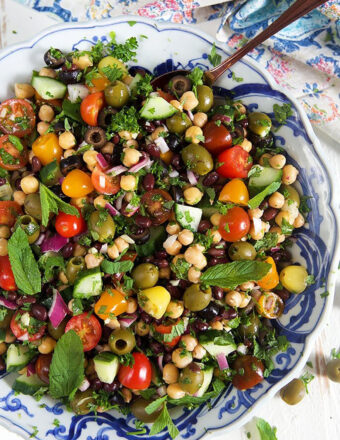 overhead shot of mediterranean chickpea salad in a blue and white bowl.