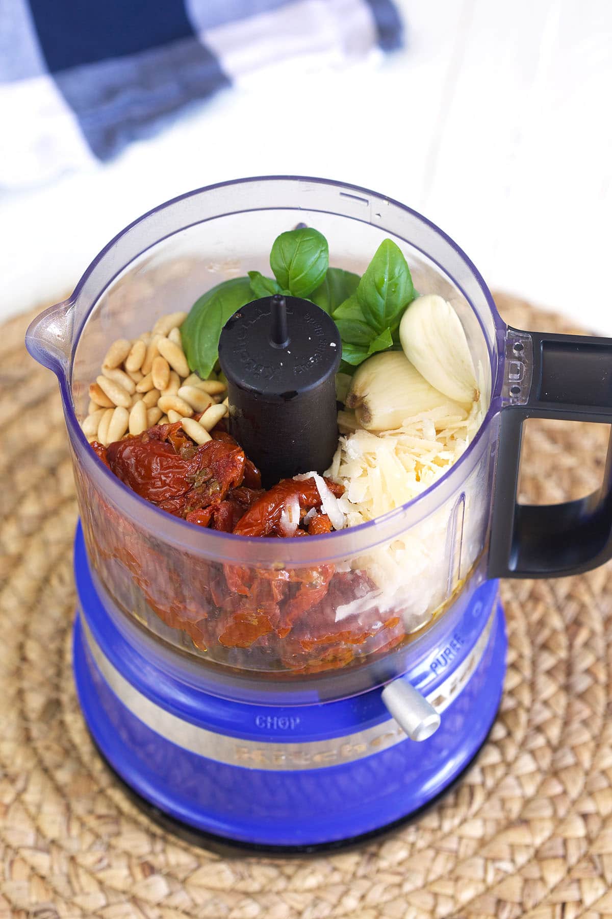 The ingredients for pesto are placed in a food processor.