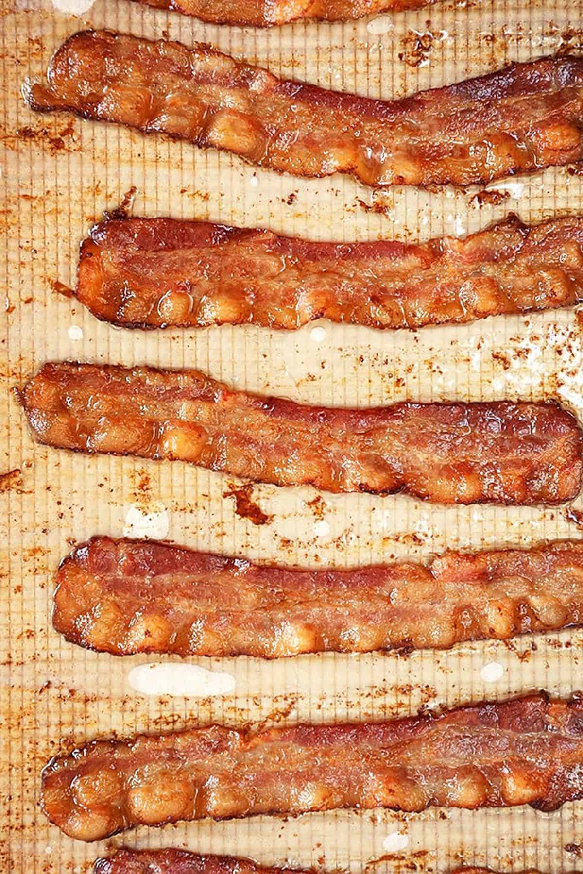 Baked bacon on a baking sheet with parchment.