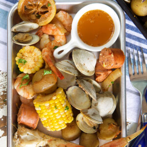 A metal plate is filled with a cajun seafood boil.