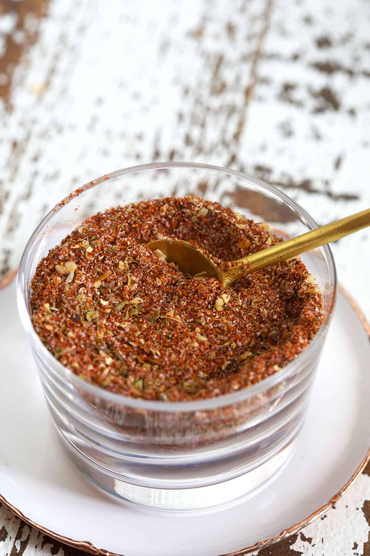 A small glass bowl contains a portion of homemade cajun seasoning. 