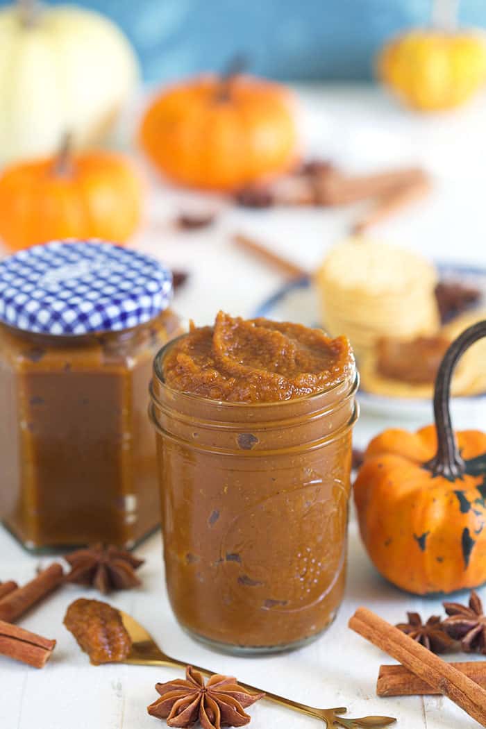Two jars of pumpkin butter are placed next to each other on a white surface. 
