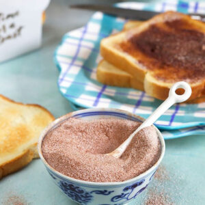 Bowl of cinnamon sugar with a white spoon.