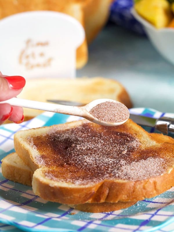 spoonful of cinnamon sugar sprinkled on a piece of cinnamon toast