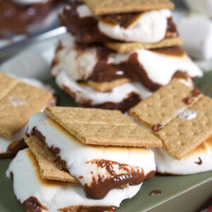 Several s'mores are placed on a green surface.