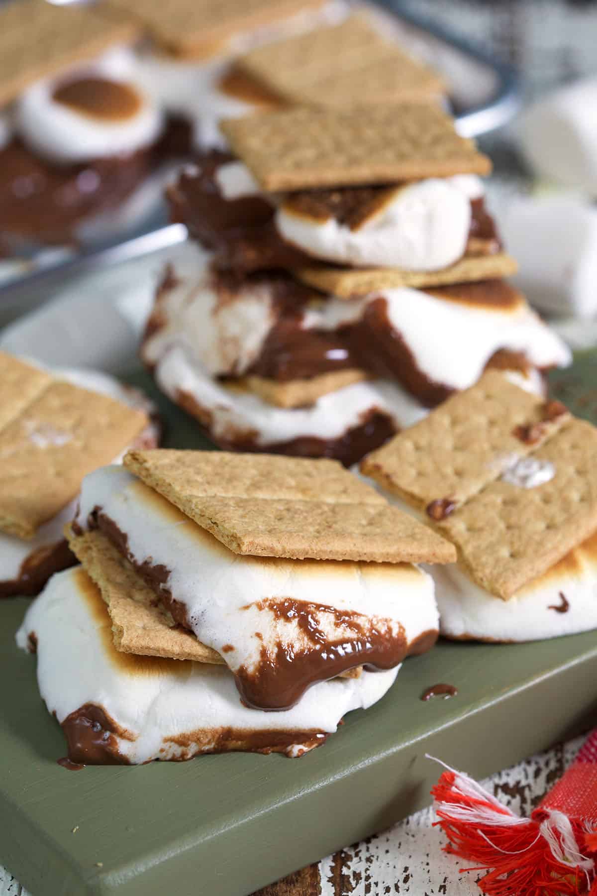 Several s'mores are placed on a green surface. 