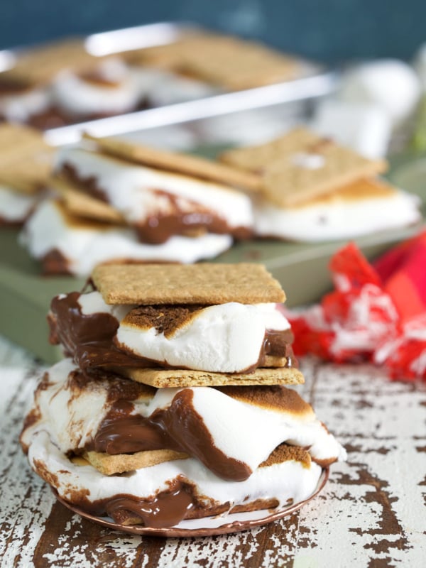 Several baked s'mores are placed next to each other on a wooden surface.