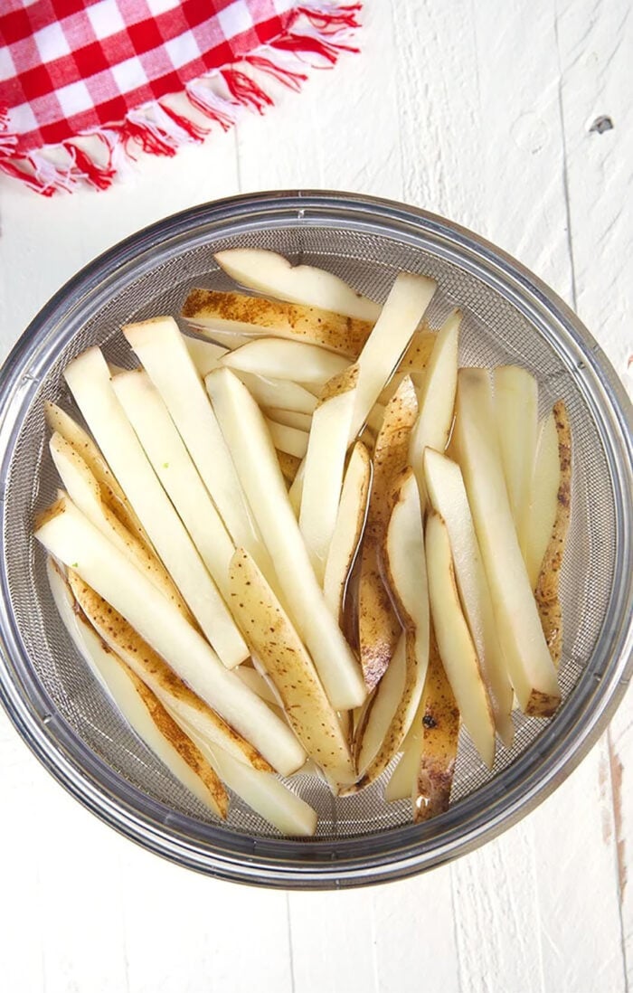 potatoes cut into fries soaking in water