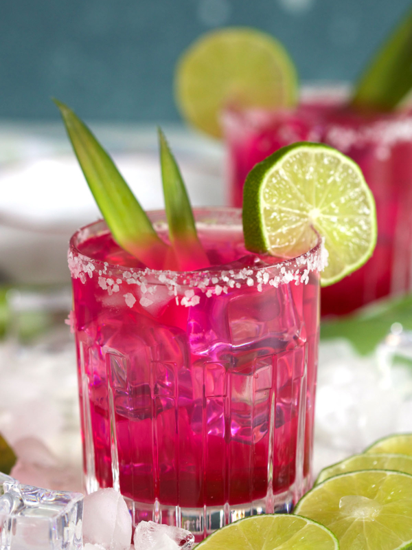 A glass filled with margarita is ready to be enjoyed on a white surface.