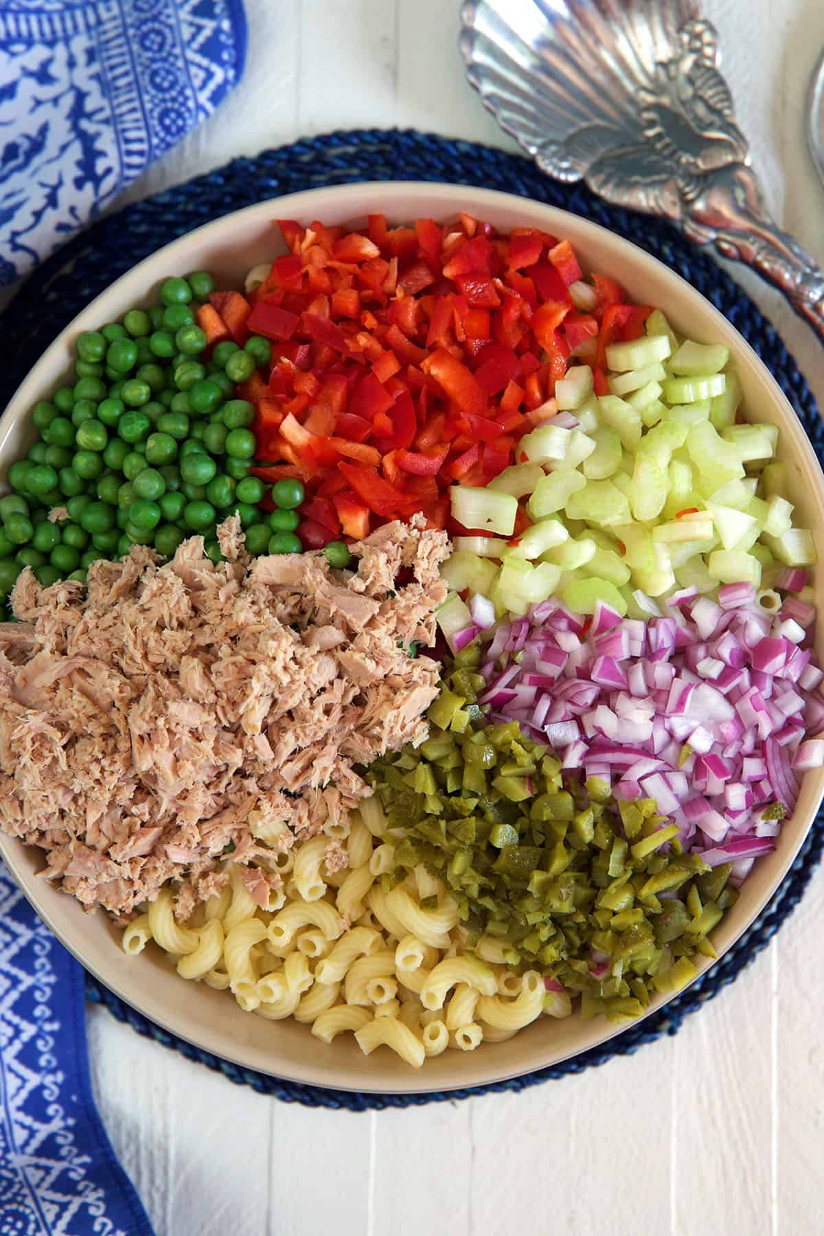 Ingredients for macaroni salad are in a large bowl. 