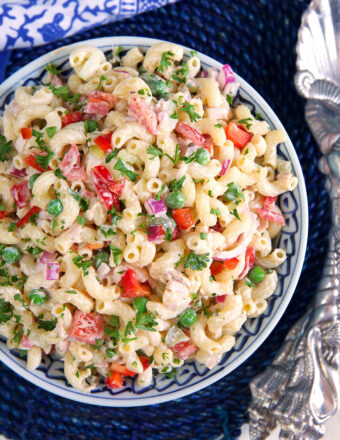 A blue and white bowl is filled with tuna macaroni salad.
