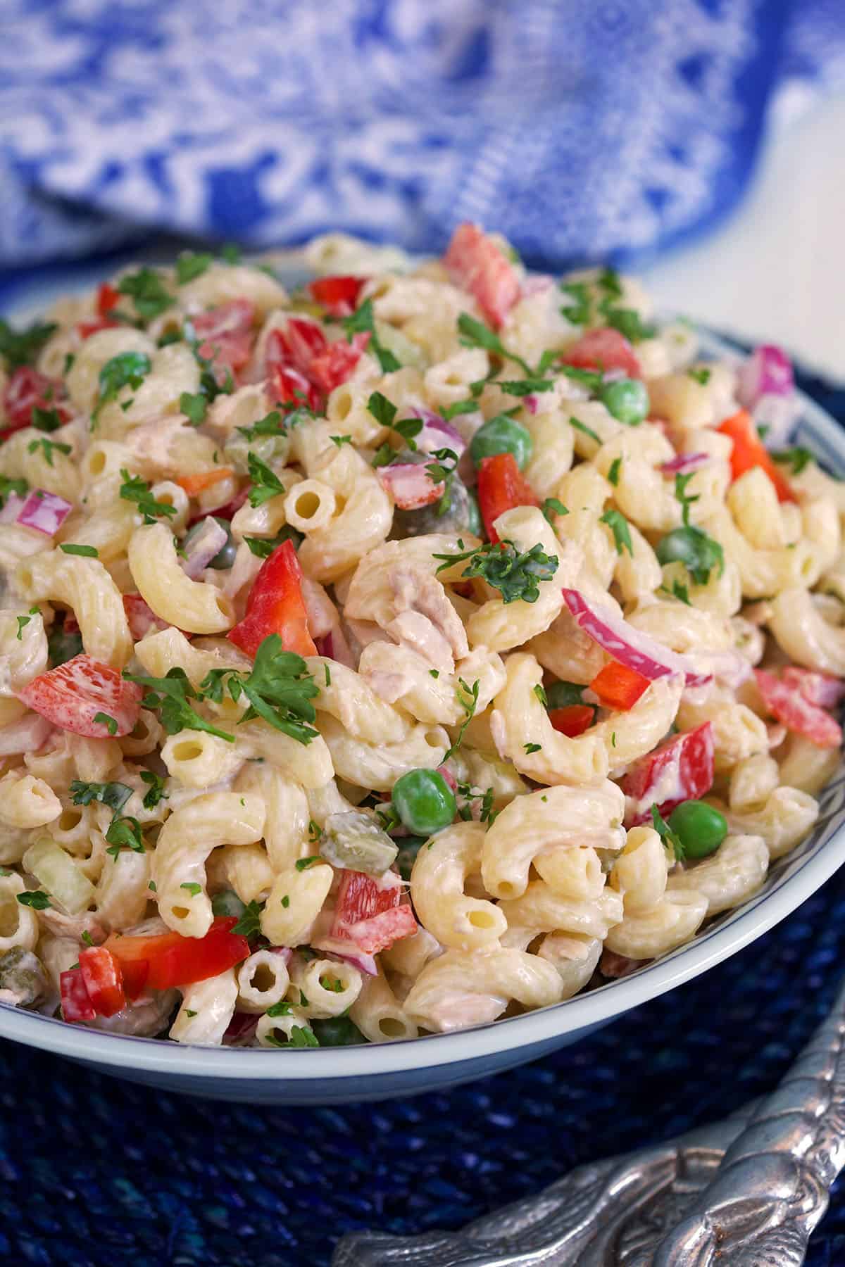 A macaroni salad is garnished with parsley. 