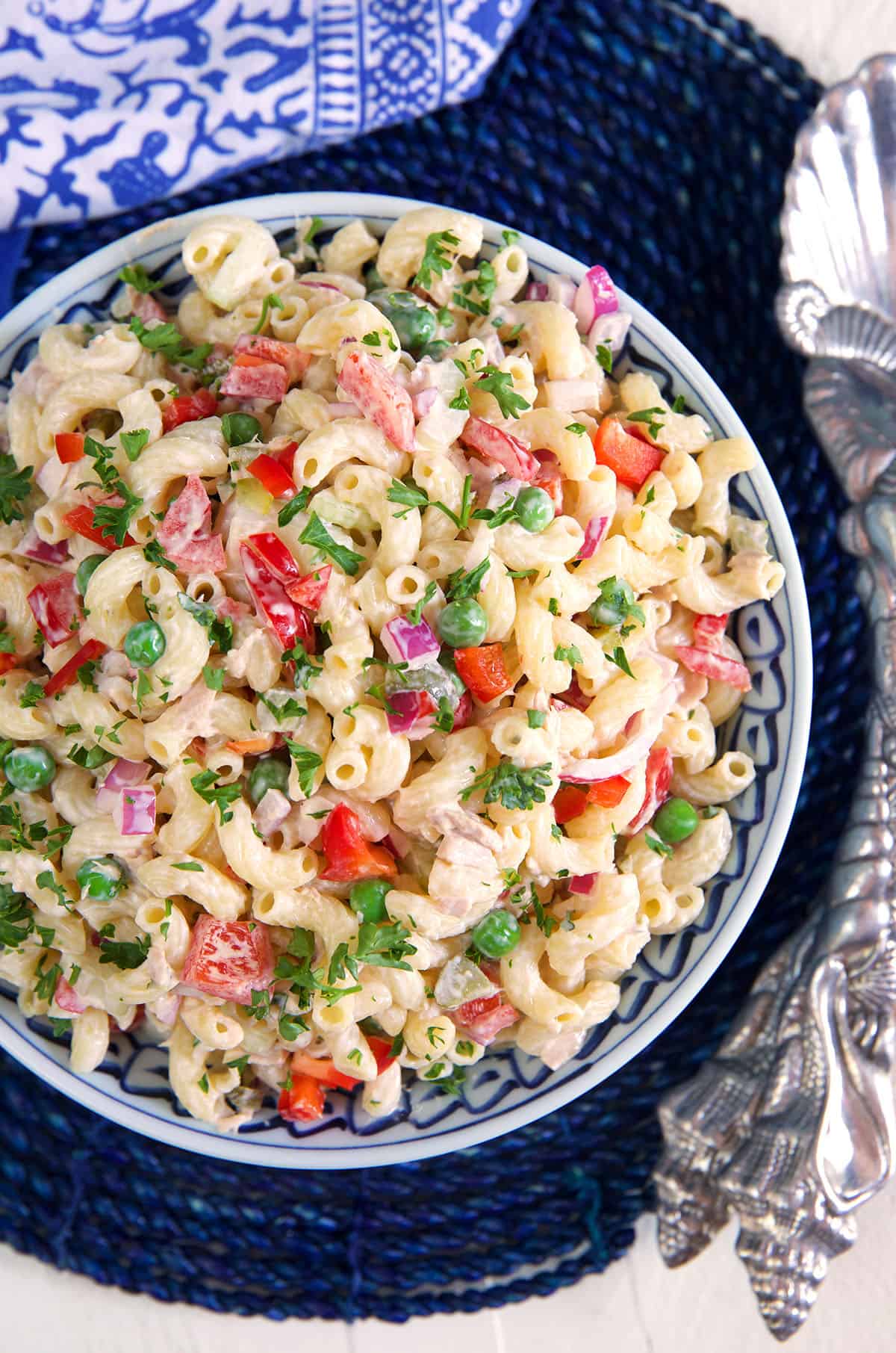 A blue and white bowl is filled with tuna macaroni salad. 