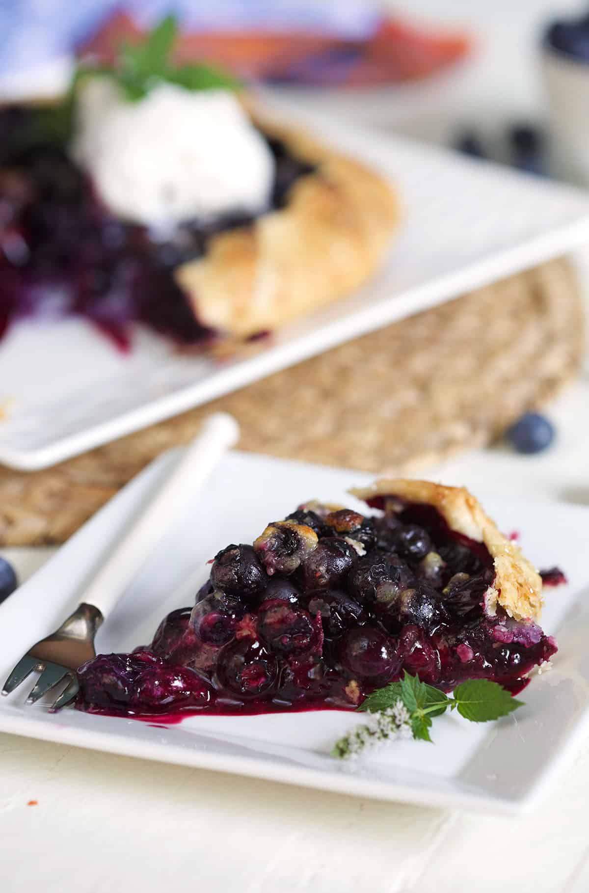 Slice of blueberry galette on a white plate