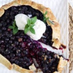 Blueberry Galette with ice cream on top and a wedge cut out of it.