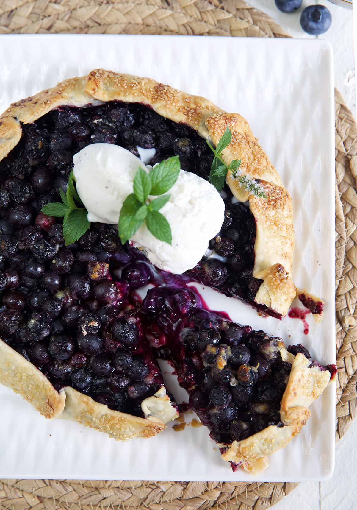 Blueberry Galette with ice cream on top and a wedge cut out of it.
